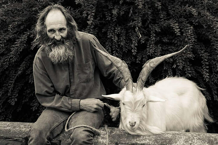 man sat with goat on a wall street photography portrait city people camera subject light how to tutorial guide