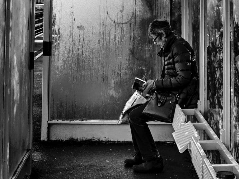 lady sat reading thinking on her own black and white portrait street photography portrait city people camera subject light how to tutorial guide