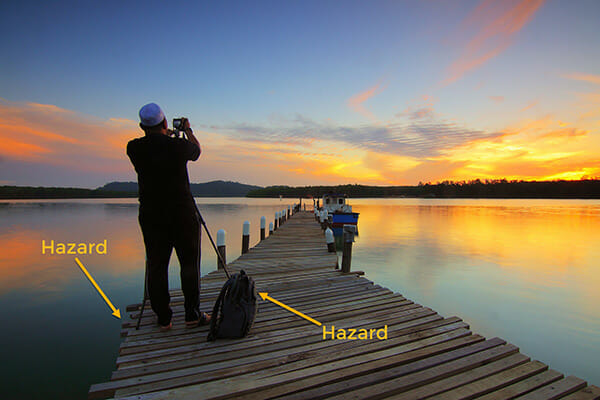 photographer stood on jetty boat in distance