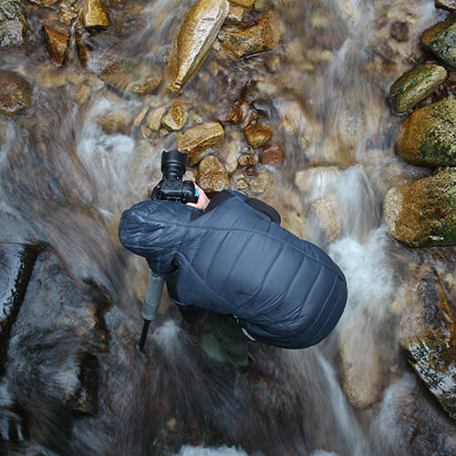 photographer rushing water camera rocks
