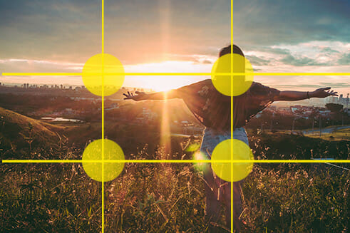 female stood arms spread sunset over city landscape