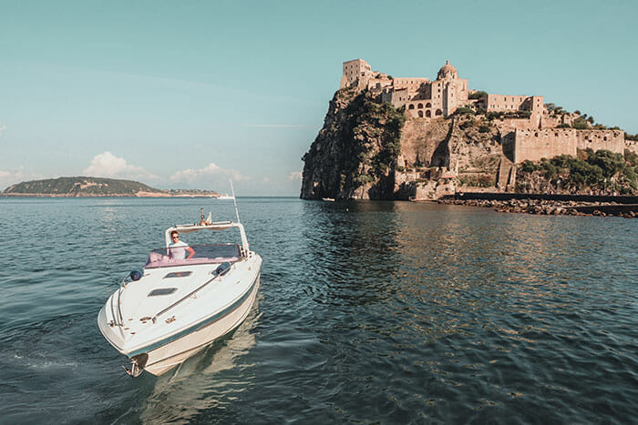 a man on a speedboat in ischia expensive camera equipment