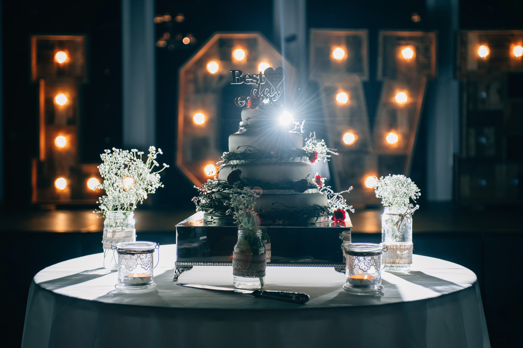 Screen Shot 2020-06-05 at 10.45.26 a wedding cake with a lens flare behind it