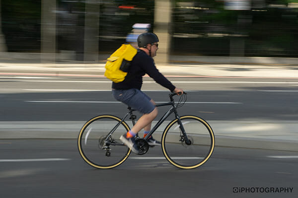 iPhotography Copyright 2020 Why Are My Pictures Blurry cyclist blurred with a yellow bag