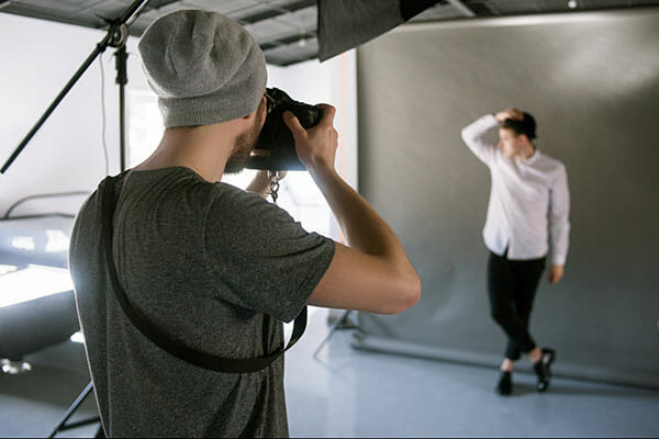 Unrecognizable,Casual,Photographer,Taking,Shots,Of,Male,Model,In,Studio. working with models Unrecognizable casual photographer taking shots of male model in studio. Fashion photoshoot backstage