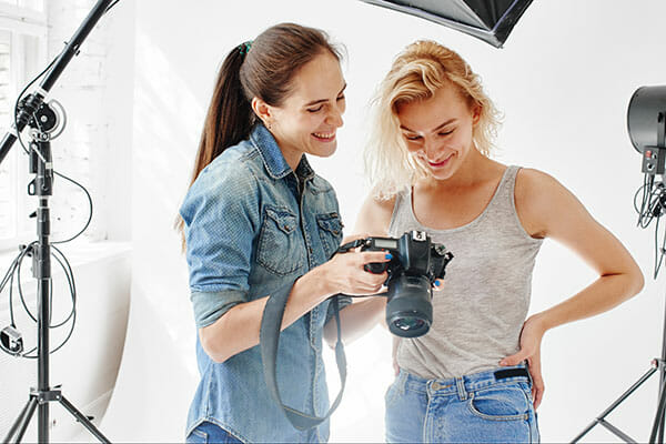 Girl,Photographer,Shows,The,Picture,Of,The,Model Girl photographer shows the picture of the model working with models