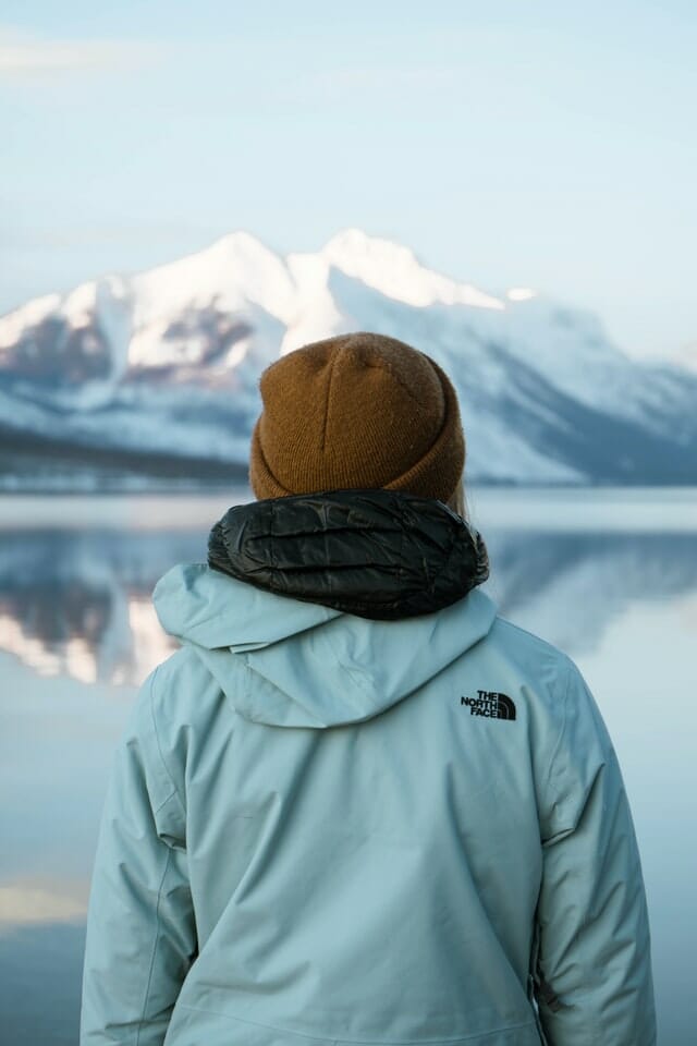 coat back of a person looking at snowy mountains