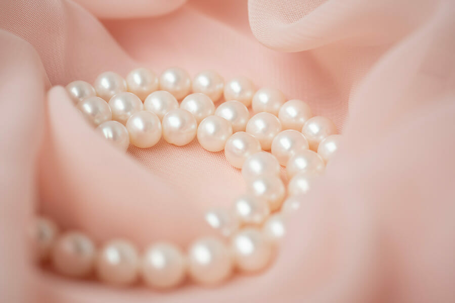 Woman,Necklace,Of,Natural,Pearls,On,Pink,Gentle,Chiffon,Fabric How to Photograph Jewelry 10