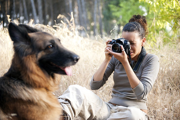 Young,Photographer,Taking,A,Photo,Of,Her,Dog Wildlife Photography Tips