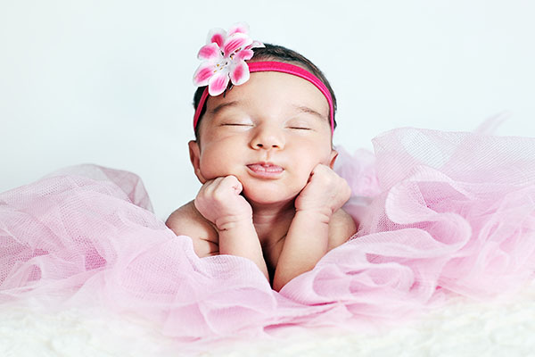 Newborn,Baby,Girl,Posing,In,Tutu,Skirt,And,Flower,Head