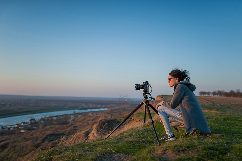 Girl,Takes,Pictures,Of,The,Landscape Photographer sat with camera on tripod